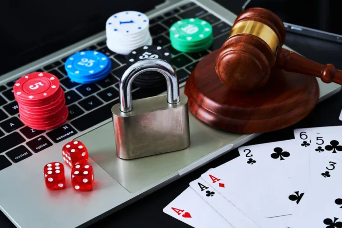 Padlock, poker chips, dice and playing cards on an open latop