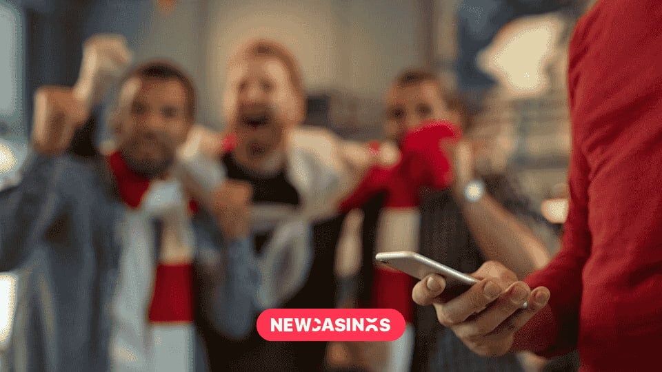 Fans celebrating their team's victory with another person checking their phone.