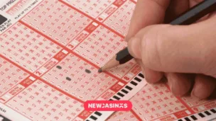 UK National Lottery and Digital Push Lift Allwyn’s Q1 Results a hand holding a pencil while crossing out options on a lottery slip