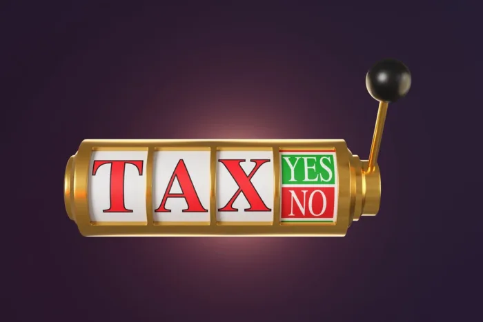 BGC Appeals for Fair Treatment of Betting as UK Economy Strengthens Golden casino slot machine with a pull handle showing the word TAX and an option of YES and NO in purple background