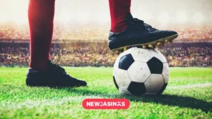 Premier League Moves to Phase Out Front-of-Shirt Gambling Sponsors A football on pitch with a player standing beside it.