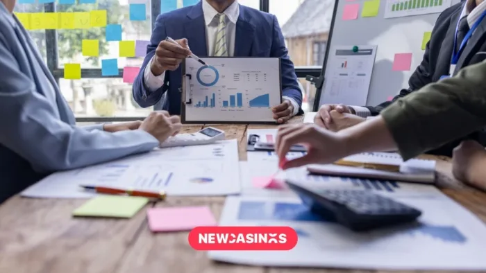 Business people sat at a meeting table, discussing graphs and charts.