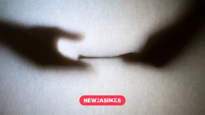 Silhouette of paper being passed from one hand to another.