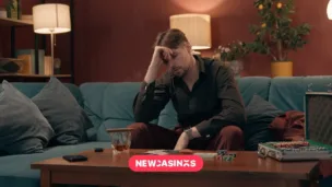 A man sits and seems upset by his table with gambling apparatus