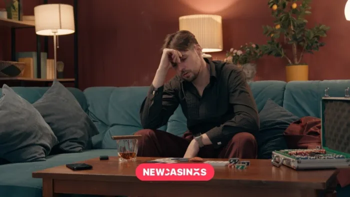 A man sits and seems upset by his table with gambling apparatus